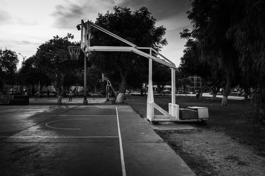 A monochrome view of an outdoor basketball court in Trujillo, Peru, capturing a quiet moment.