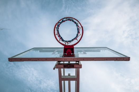 Upward view of a basketball hoop and backboard against a blue sky in Trujillo, Peru.