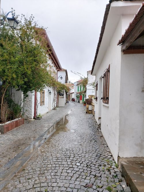 Free Picturesque scene of a narrow cobblestone street lined with whitewashed houses, perfect for travel inspiration. Stock Photo