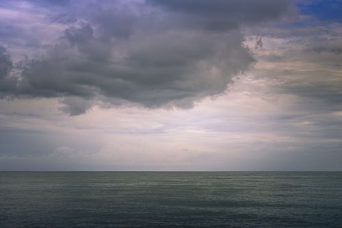 Free A captivating view of the ocean under a dramatic cloudy sky, showcasing nature's vastness and tranquility. Stock Photo