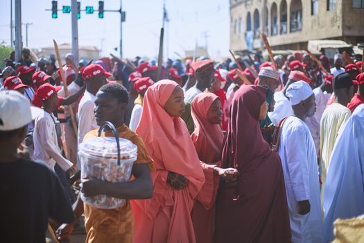 View of a diverse crowd at a street parade, showcasing traditional attire and vibrant energy.