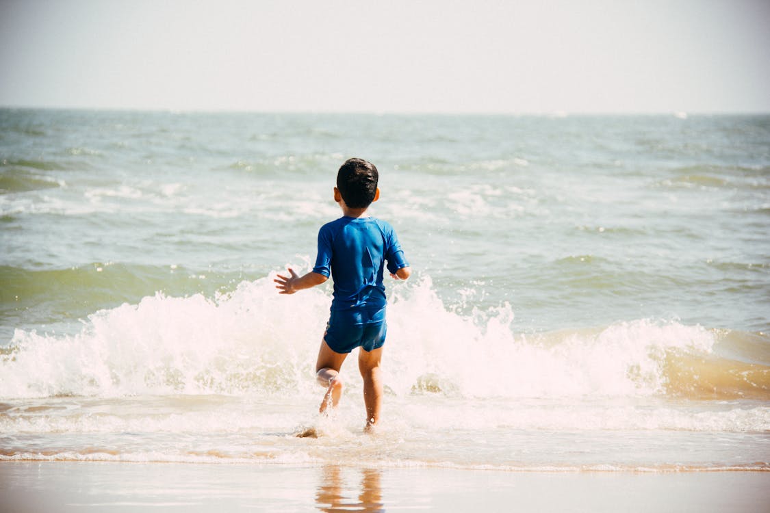無料 海岸を歩く少年 写真素材