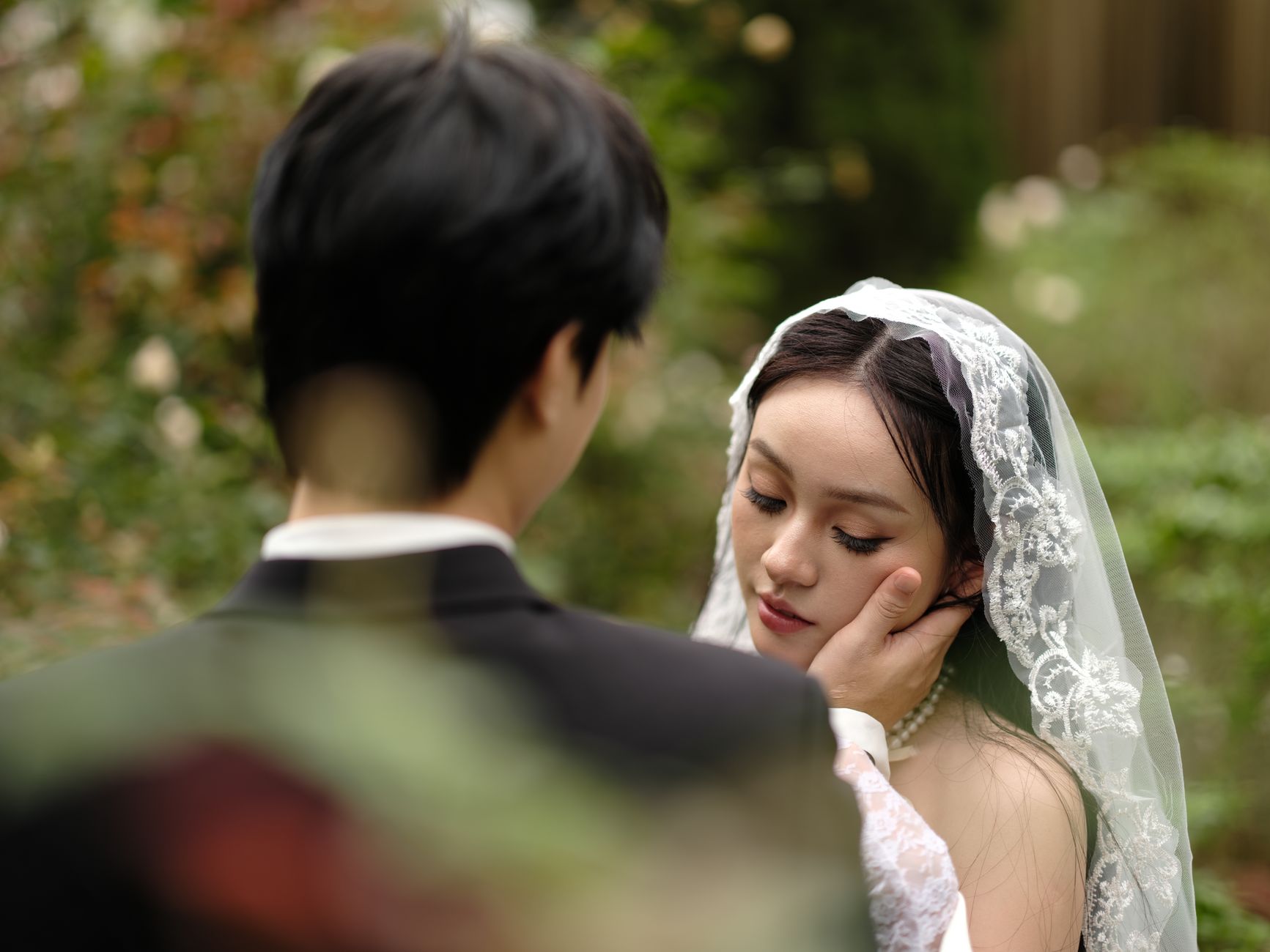 A tender moment between a couple during an outdoor garden wedding.