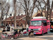People Gather Around Pink Food Truck in Urban Setting