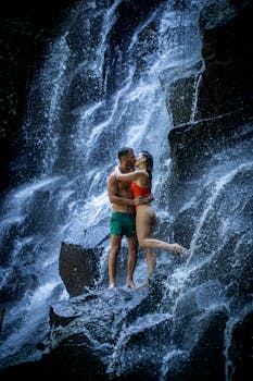 一对夫妇在瀑布下共享亲密时刻