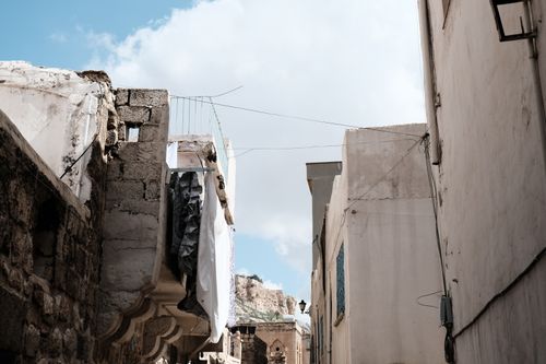 Free A scenic view of aged stone buildings under a bright blue sky, capturing urban decay Stock Photo