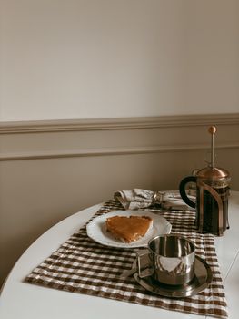 Warm, inviting breakfast table with pie, coffee, and French press.