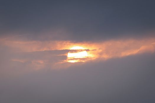 A beautiful sunset with dramatic clouds and sun rays peeking through.