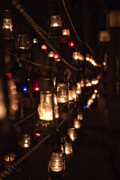 Free A moody display of hanging lanterns glowing warmly at night, creating a serene atmosphere. Stock Photo