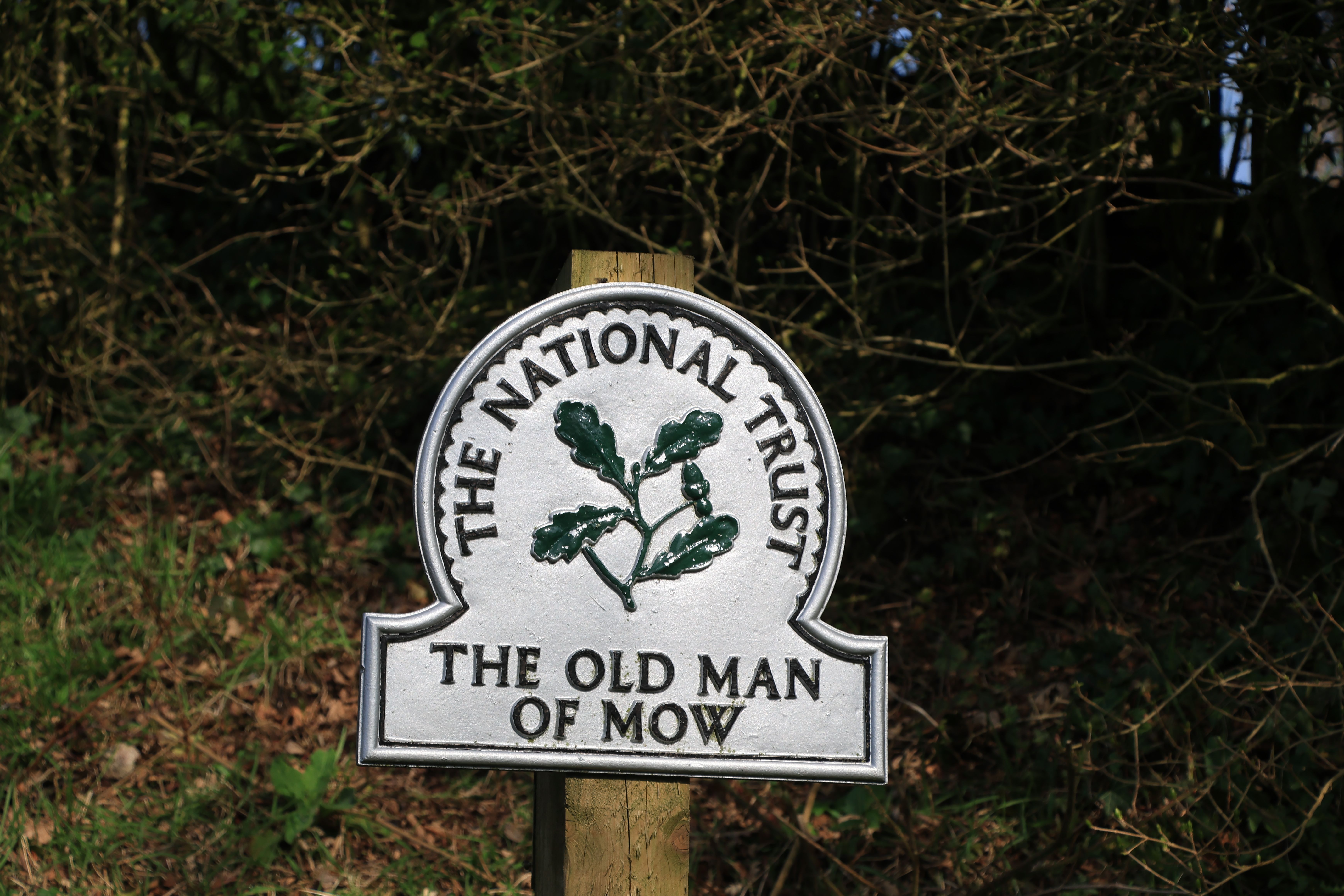 Sign for The Old Man of Mow by the National Trust, surrounded by greenery.