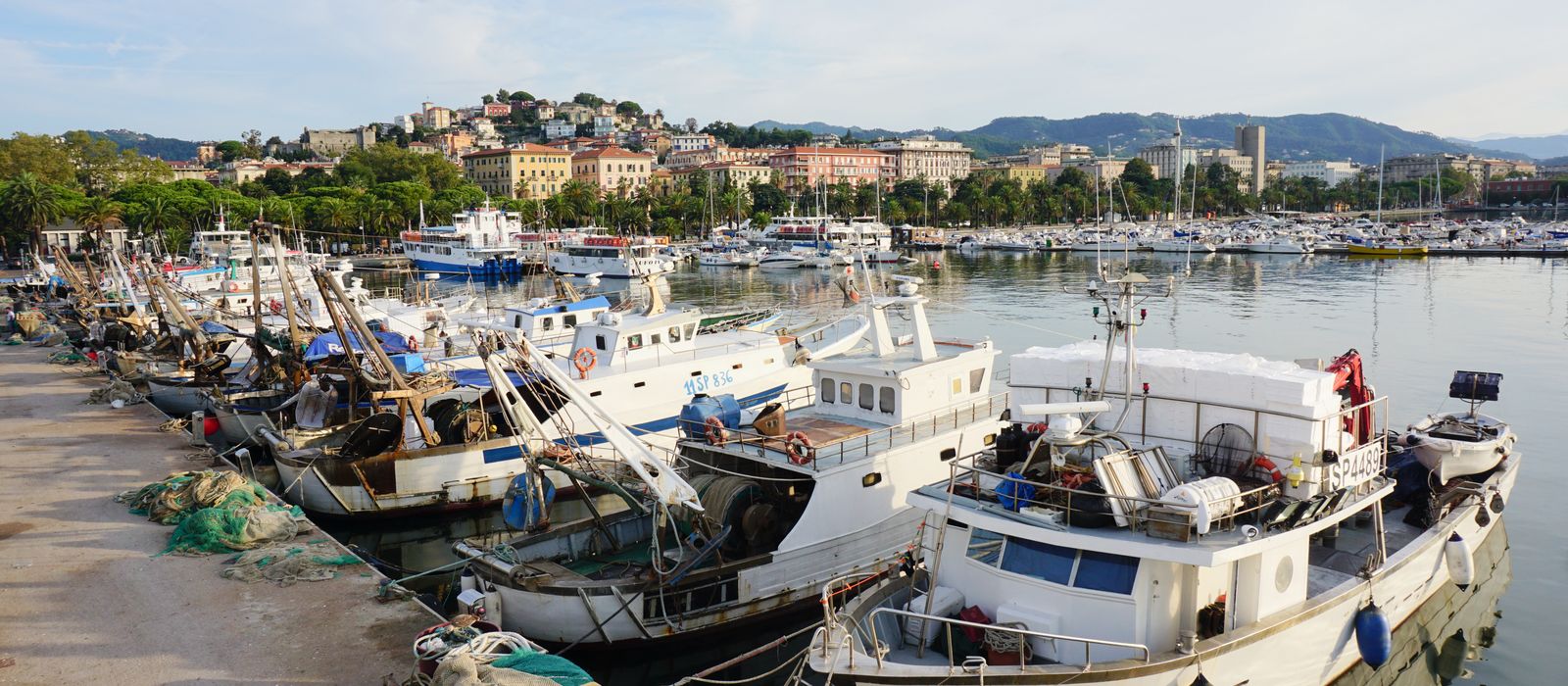 Fishing boats docked at La Spezia harbor, capturing scenic coastal Italy charm.