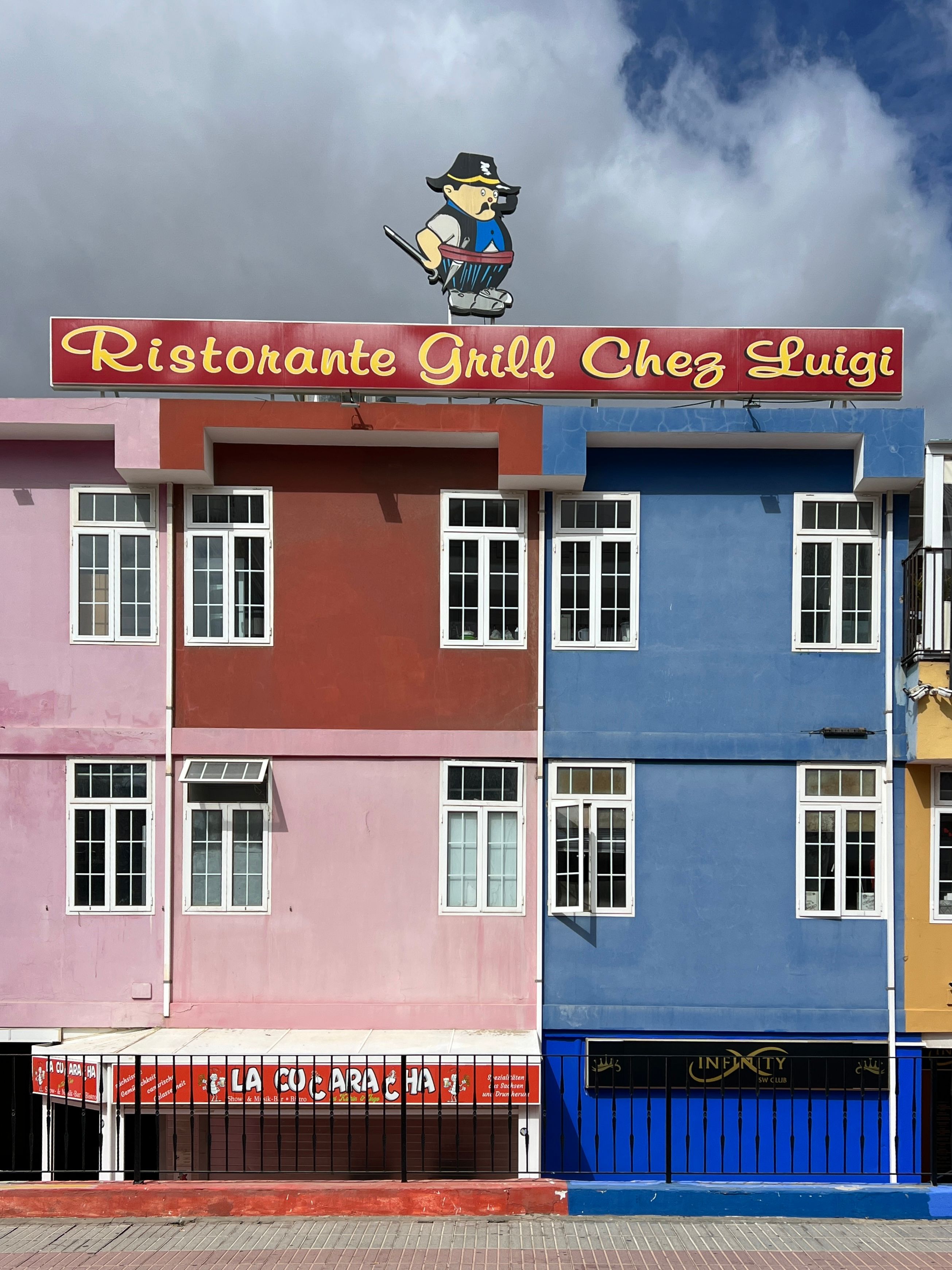Vibrant facade of a building with 'Ristorante Grill Chez Luigi' sign and colorful walls.