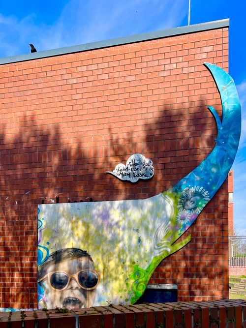 Free Colorful street art featuring a painted face and abstract elements on a brick wall in Germany. Stock Photo