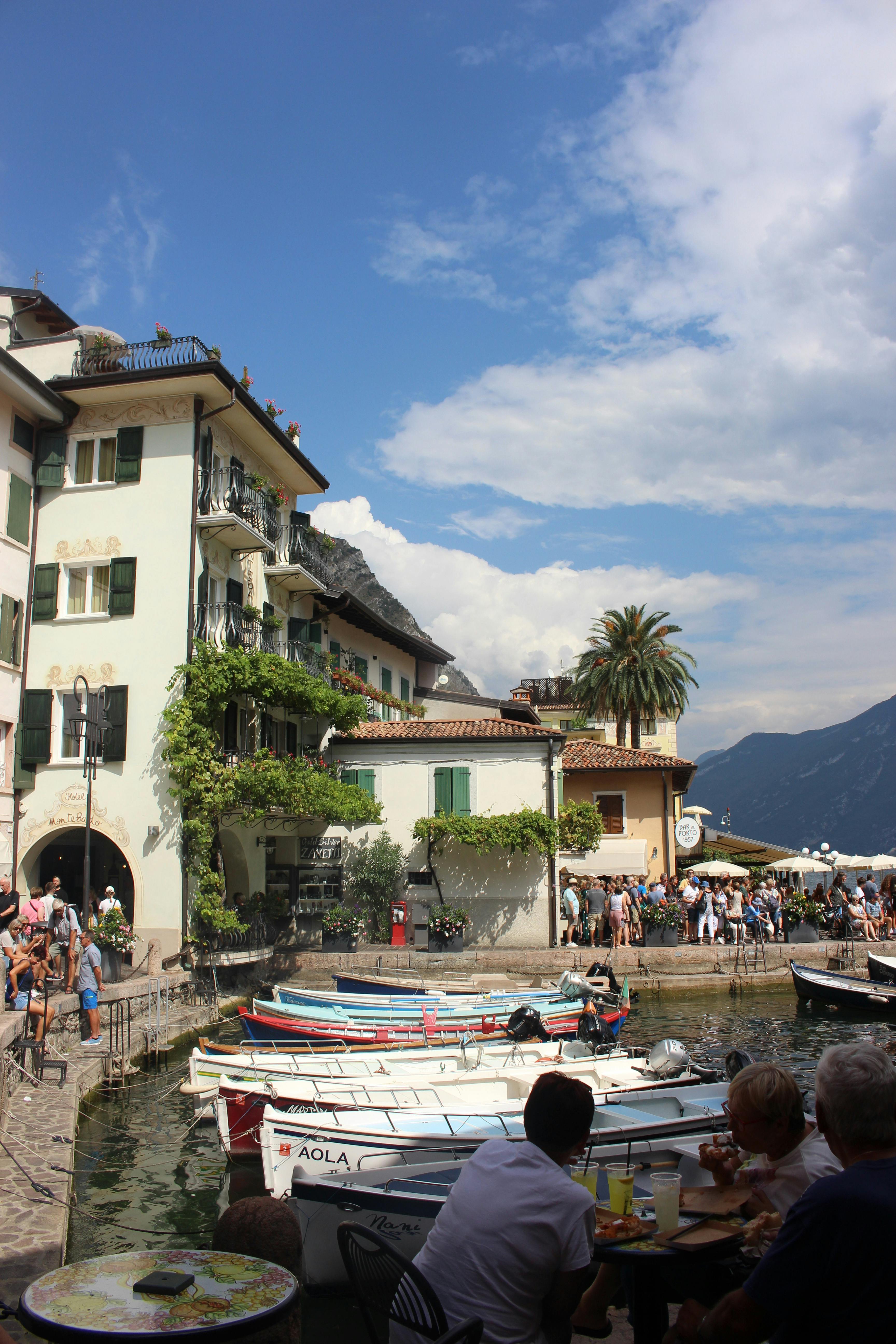 A picturesque view of a bustling waterfront on Lake Garda, showcasing Italian charm and vibrant activity.