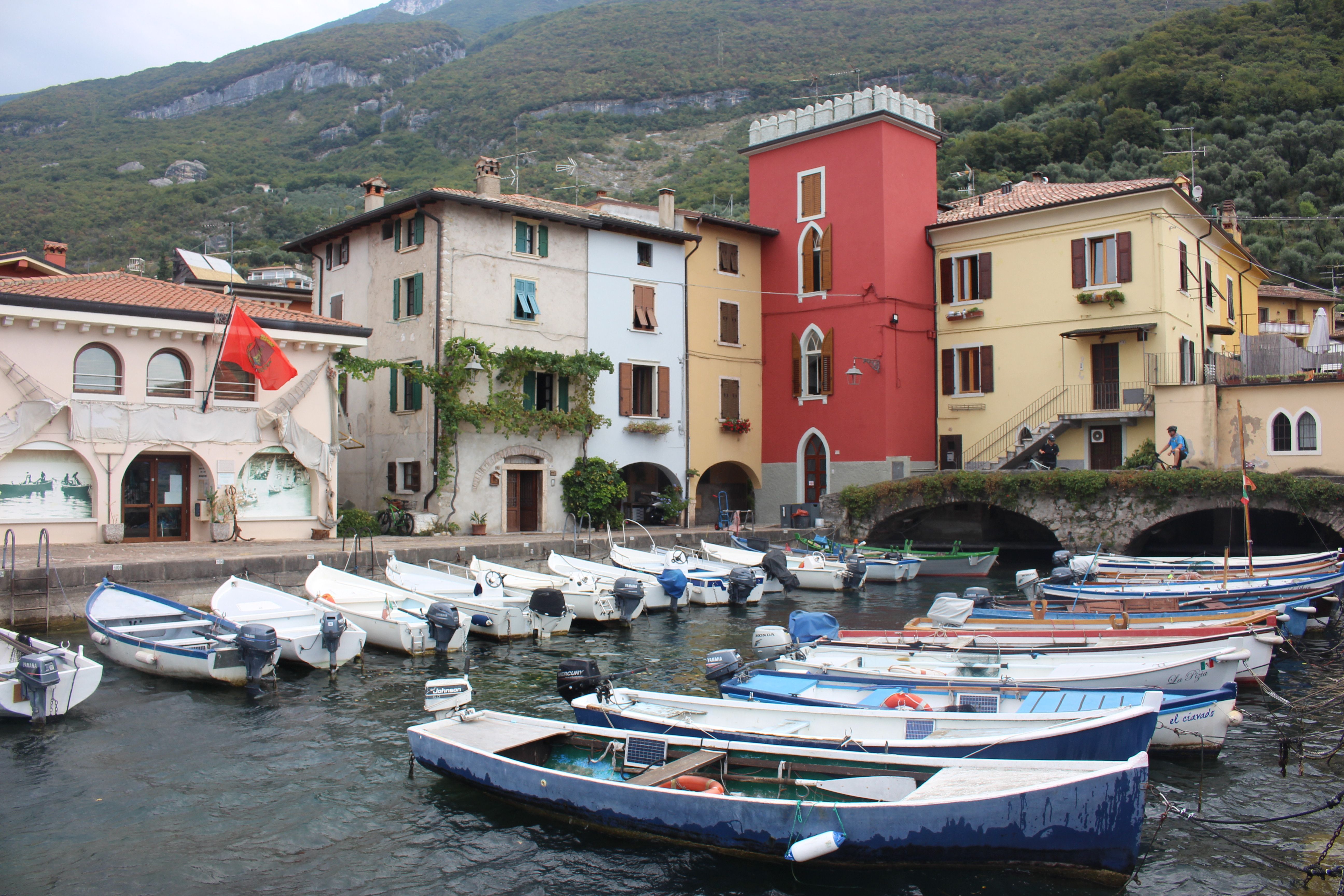 Charming Italian harbor with vibrant buildings and traditional boats at Lake Garda.