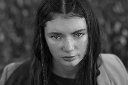 Engaging portrait of a young woman with intense gaze, shot in black and white.