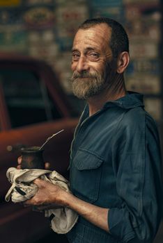 Portrait of a happy mechanic enjoying mate in a rustic garage setting in Balcarce, Argentina.