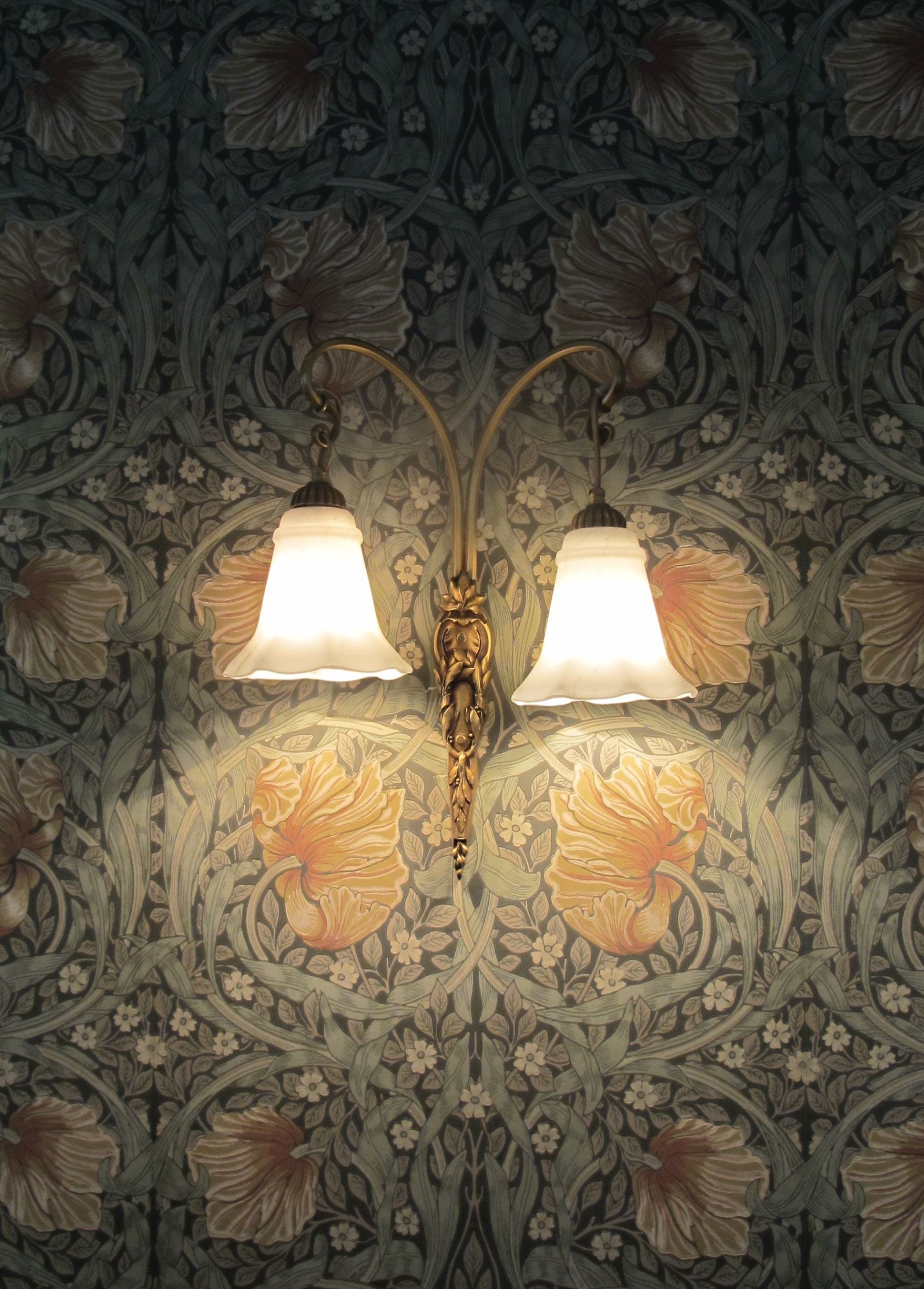Gratis Elegant vintage-lampe på blomstret tapet indfanger en klassisk café-æstetik. Lagerfoto