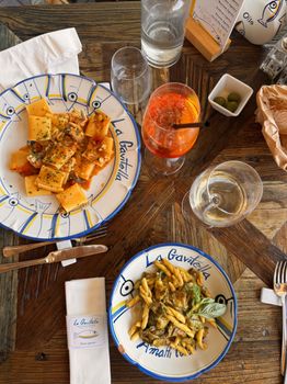 Discover delicious Italian dishes at La Gavitella in Praiano, Italy, featuring vibrant pasta and refreshing drinks.