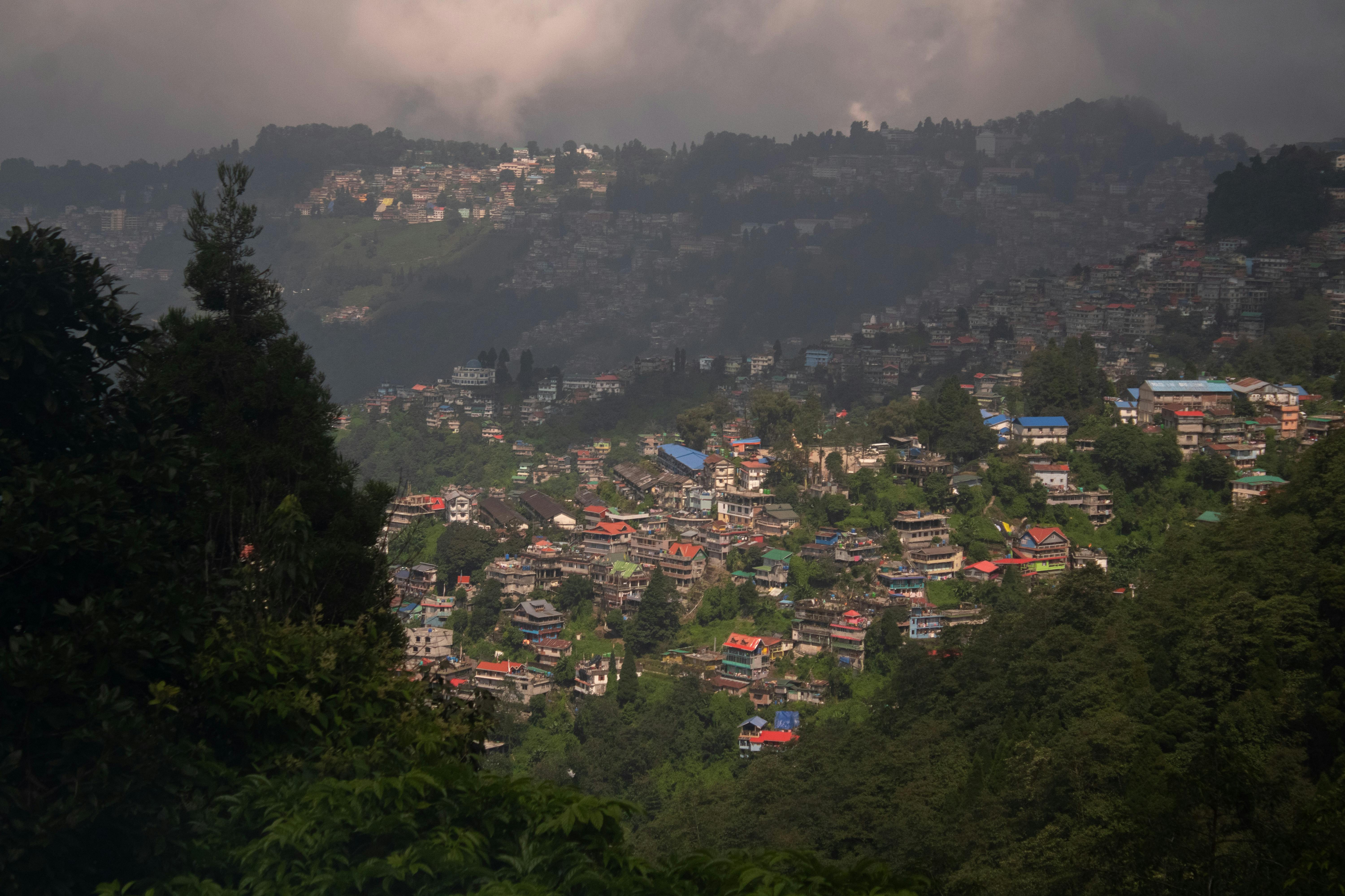 Scenic aerial view of a hillside town surrounded by lush greenery and forests.