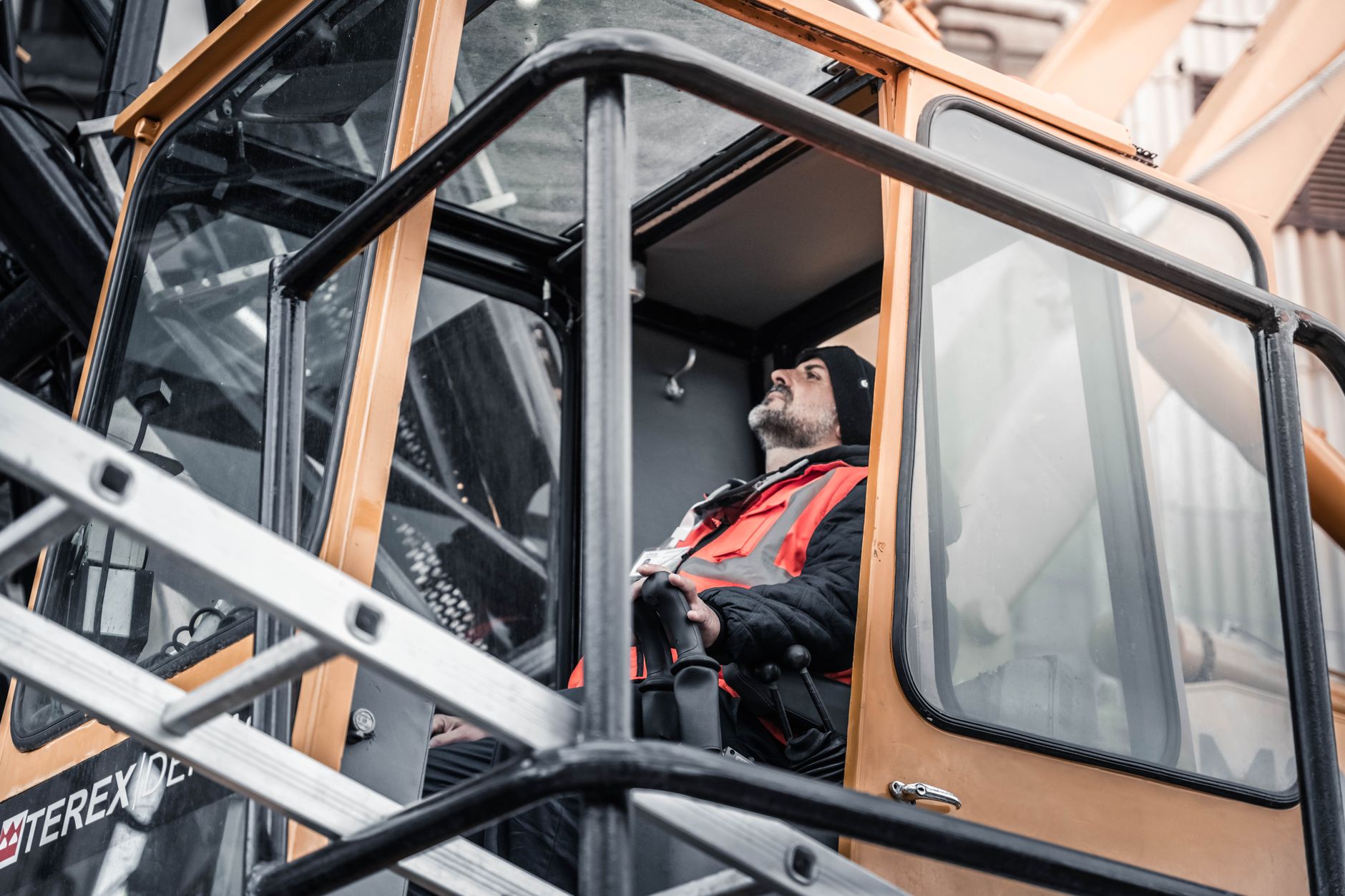 Conducteur d'engin lourd dans cabine, zone de travail minière