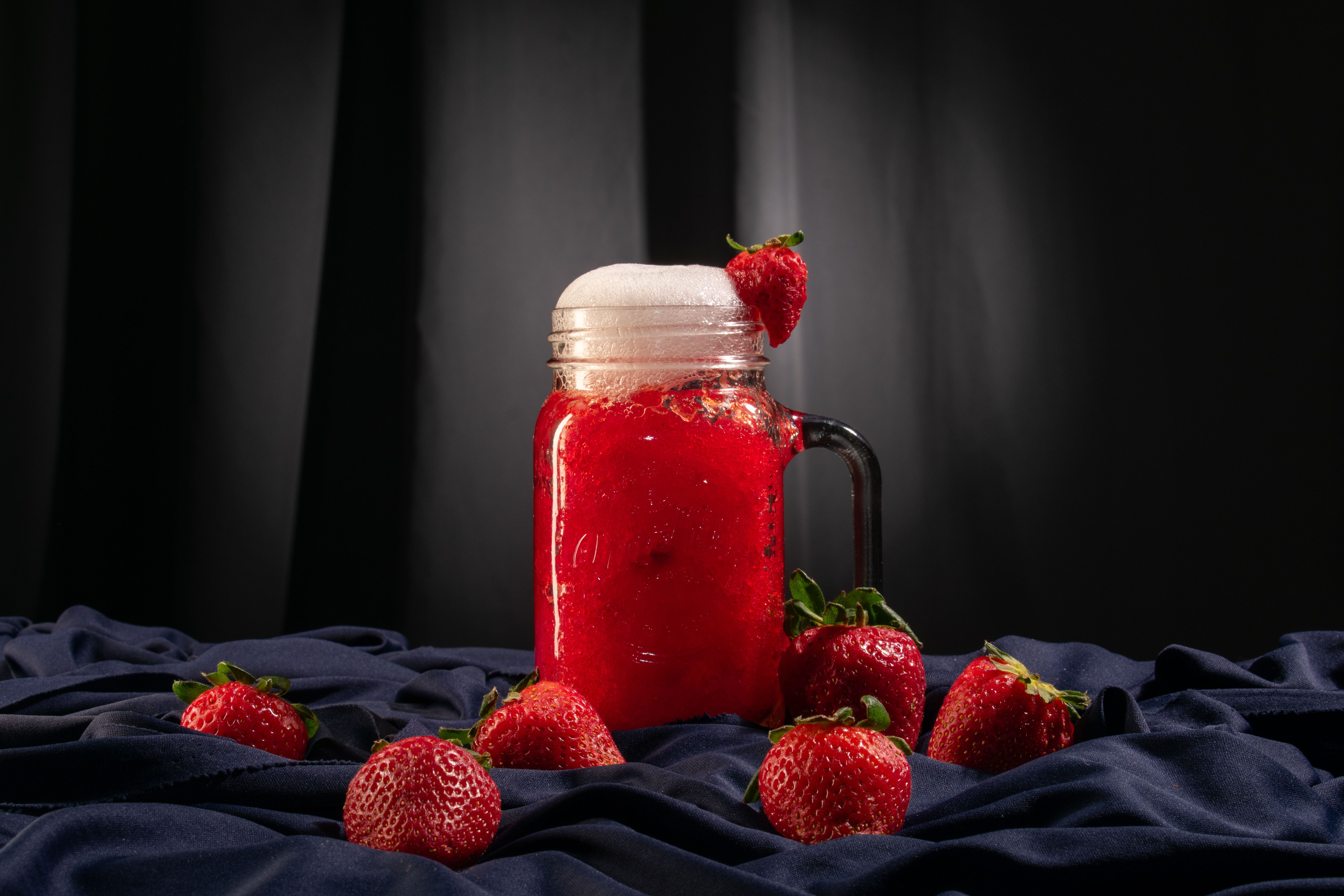 Glass with creamy strawberry soda and fresh strawberries