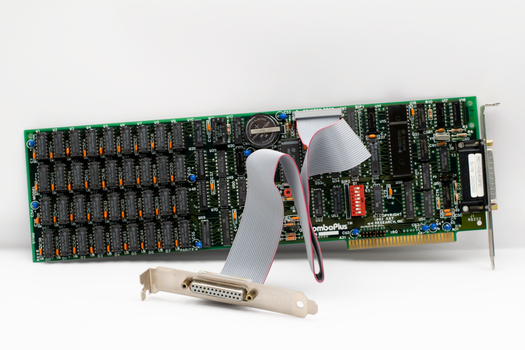 Close-up of a vintage computer expansion card featuring electronic components and a ribbon cable.