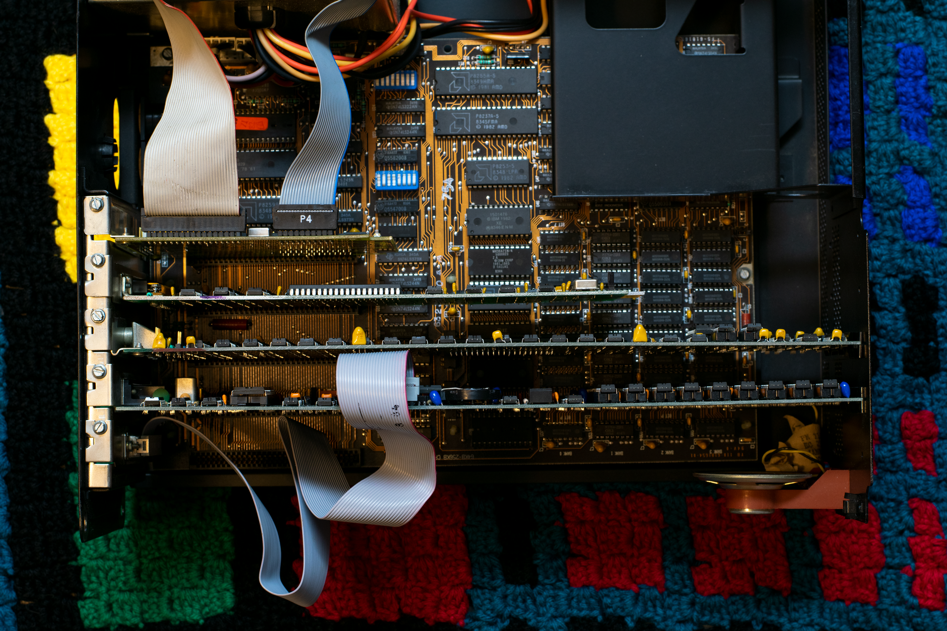 A vintage circuit board showcasing intricate electronic components and ribbon cables.