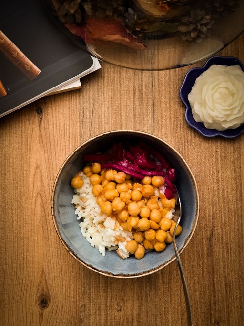 Free Delicious bowl of chickpeas, rice, and red cabbage on a wooden table, perfect for a healthy meal option. Stock Photo