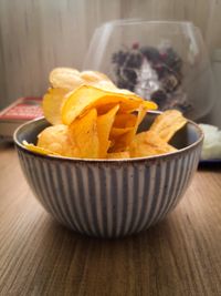 Bowl of golden kettle-cooked potato crisps — photo by fewmiracles . on Pexels