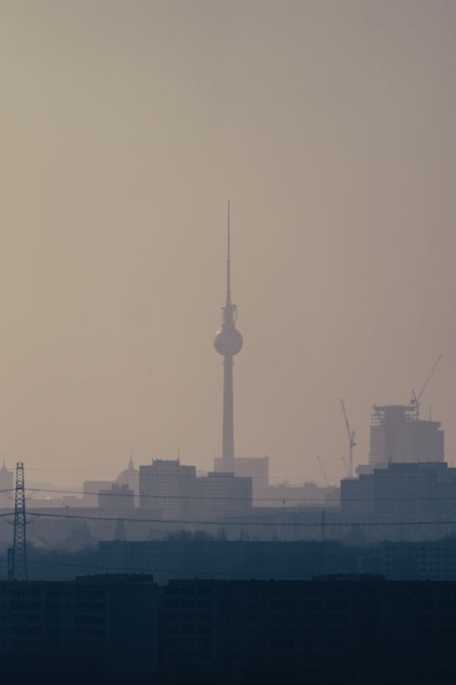 Free Silhouette of Berlin's iconic TV tower against a hazy urban skyline at dusk. Stock Photo