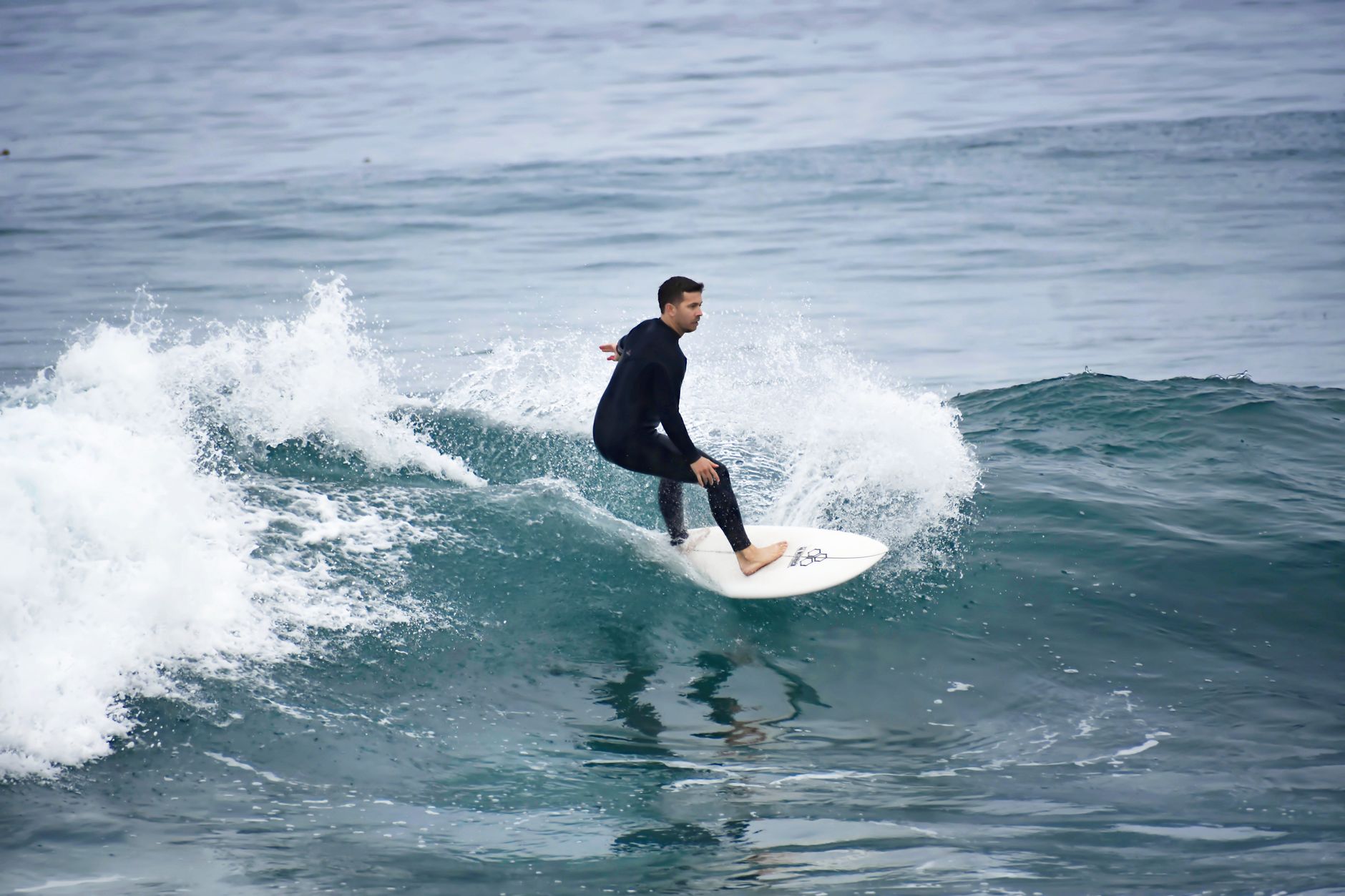 A skilled surfer balancing on the waves of the open ocean, capturing the thrill of surfing.