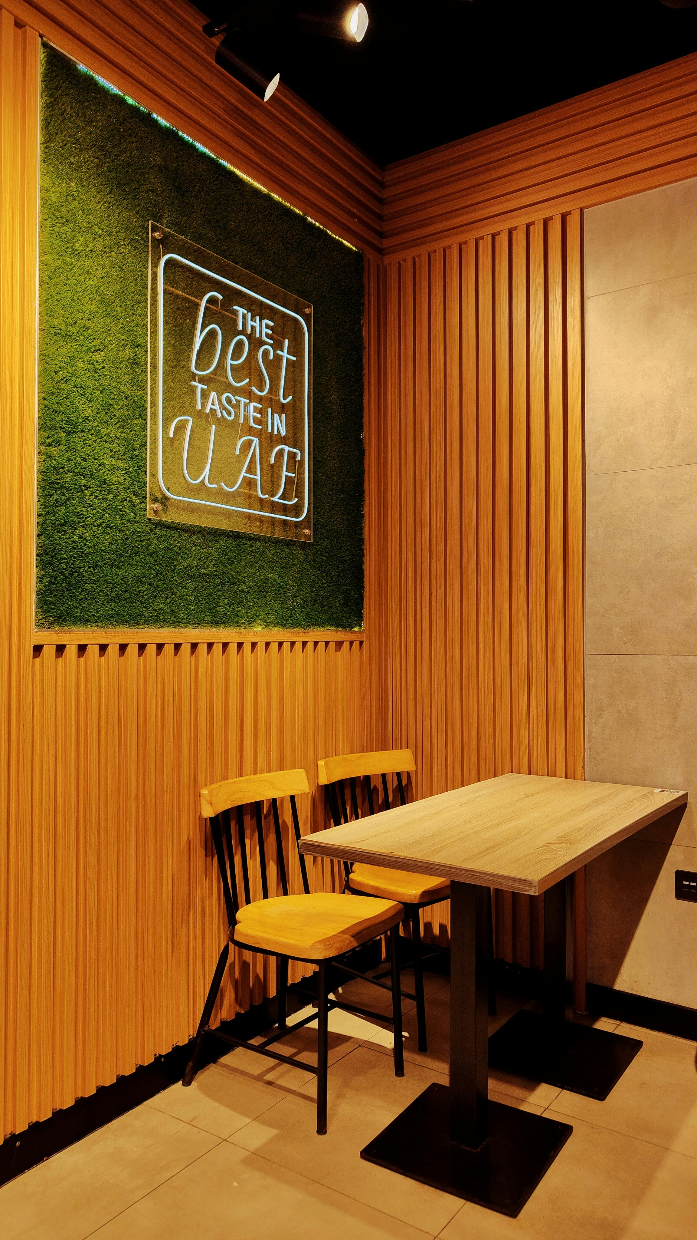 Modern dining area with special 'Best Taste in UAE' illuminated sign.