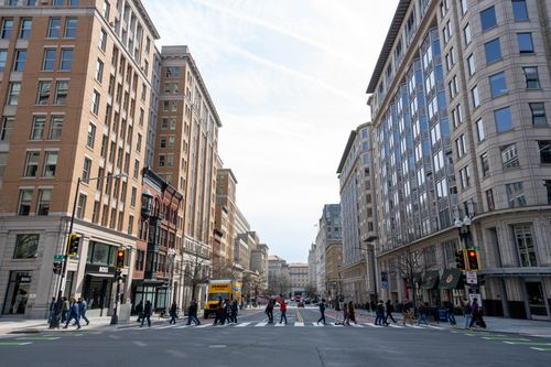 Free Downtown Washington DC road with high-rise buildings and pedestrians crossing. Stock Photo