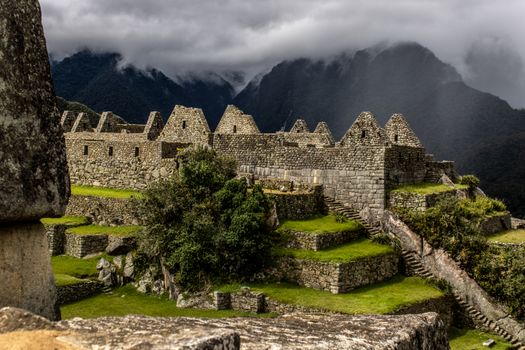 Machu Picchu ruins with misty mountains, showcasing ancient architecture and lush greenery.