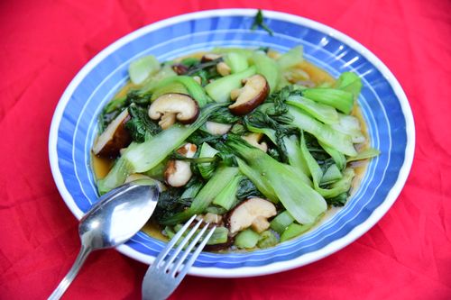 Free A vibrant plate of stir-fried bok choy and shiitake mushrooms on a colorful dish. Stock Photo