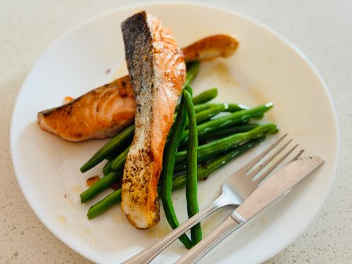 Free Delicious grilled salmon fillet served with fresh green beans on a white plate, perfect for a healthy meal. Stock Photo