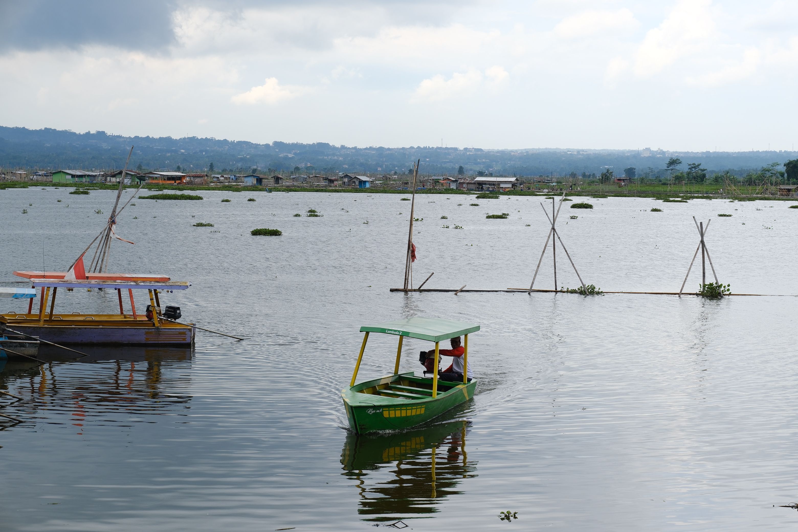Tranquil scene of colorful boats on a lake in Central Java, highlighting local life and culture.