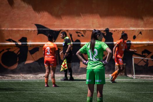 A women's soccer match captured outdoors showing players in vibrant uniforms.