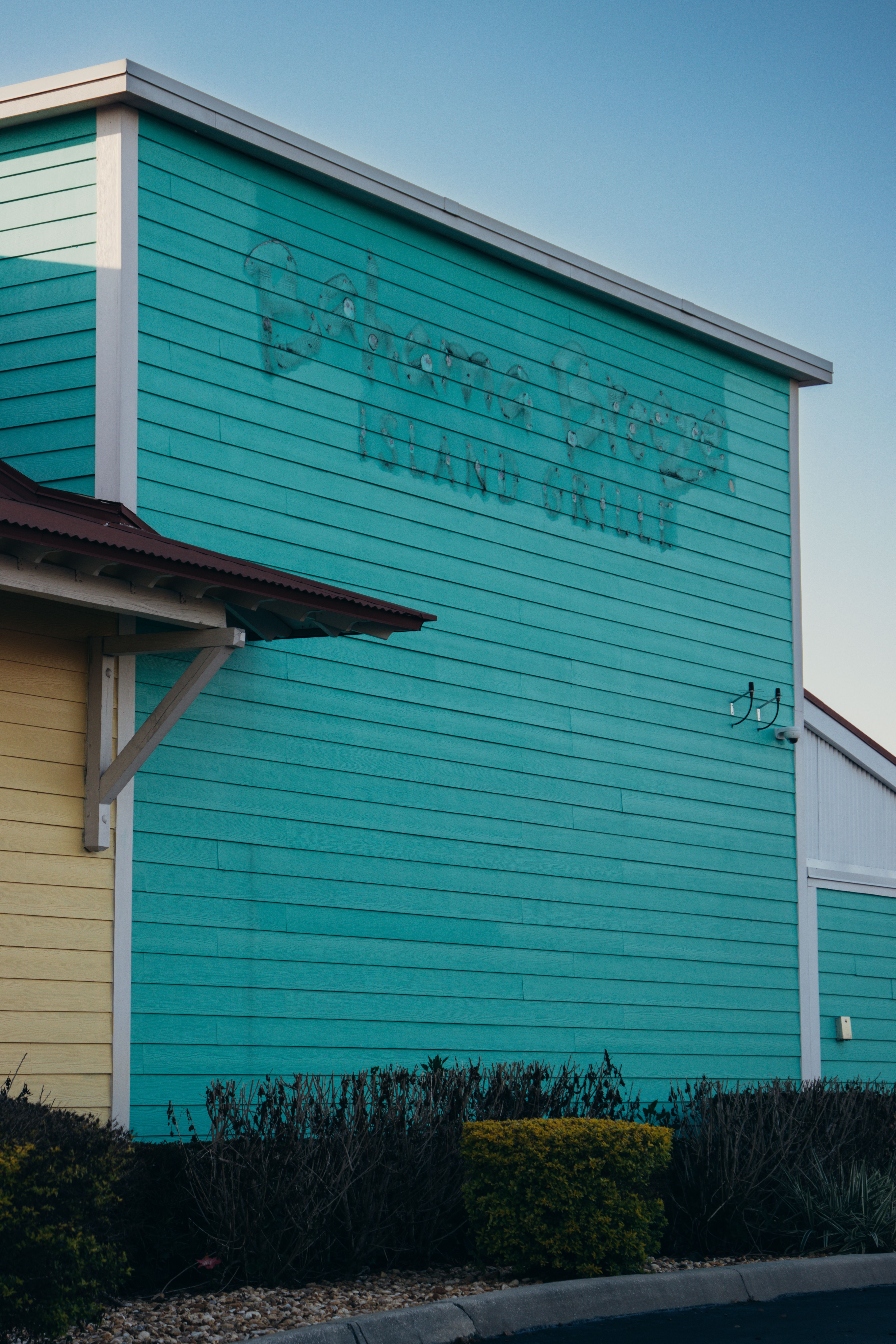 A brightly painted turquoise and yellow beachside building.