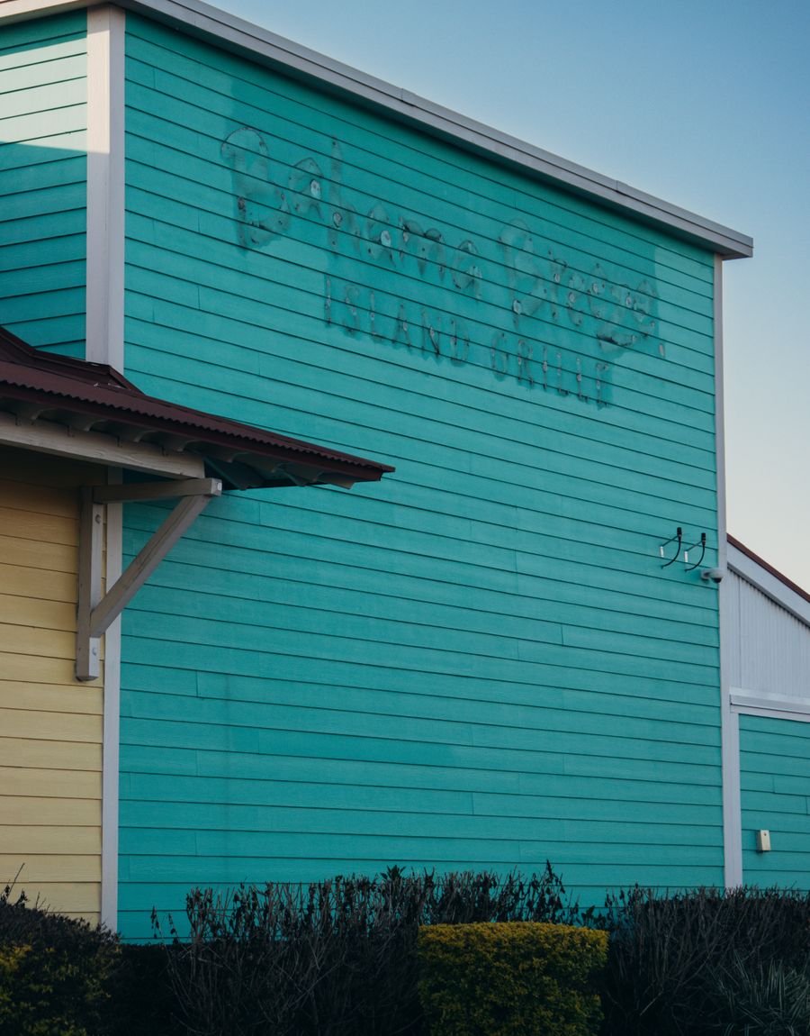 A brightly painted turquoise and yellow beachside building.