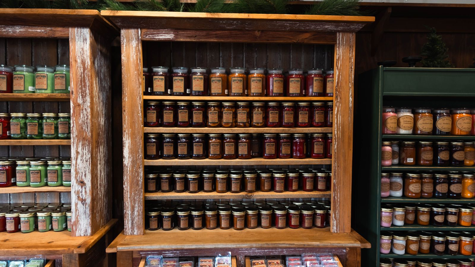 Rustic wooden shelves displaying a variety of jarred products in a cozy store setting.
