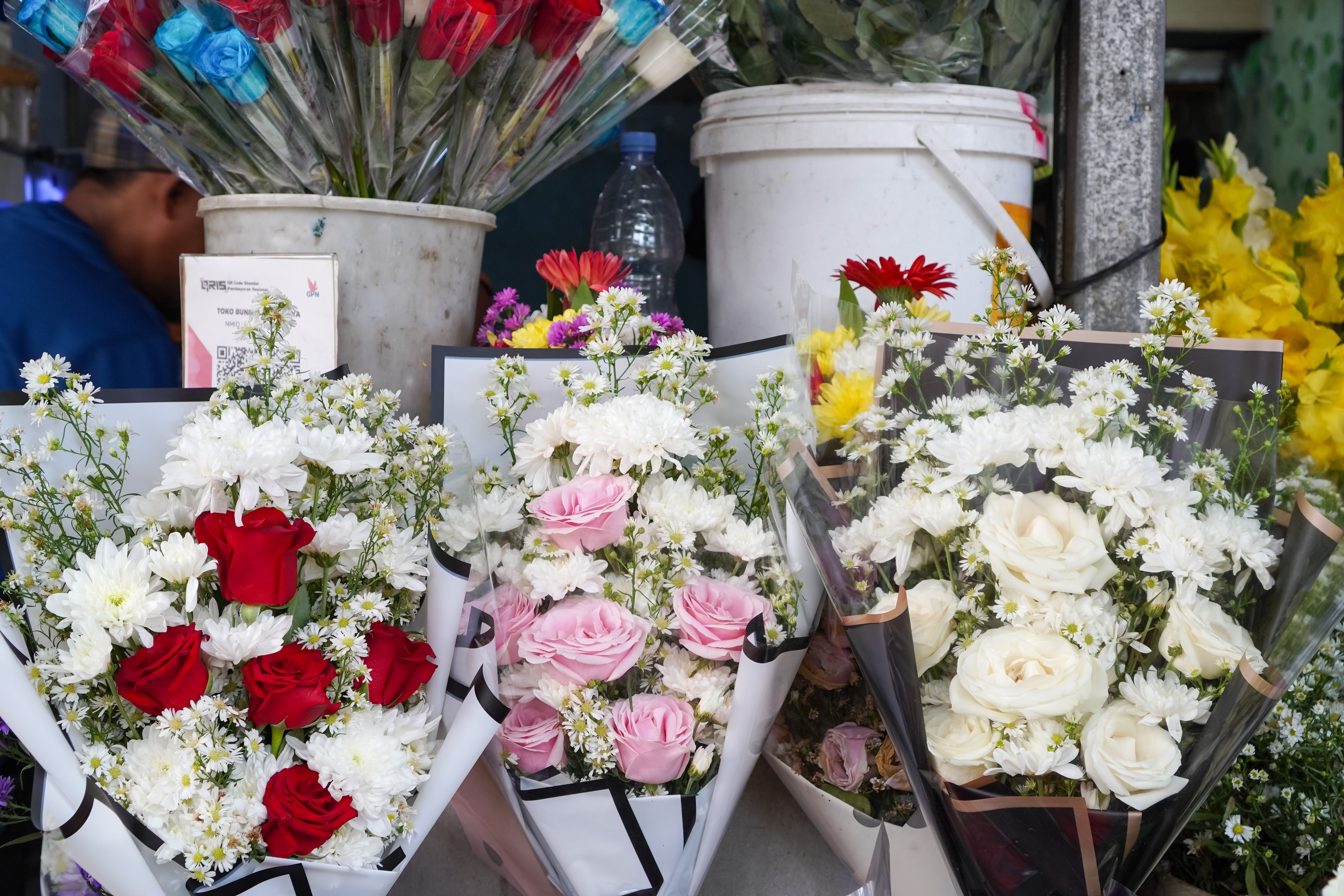 A lush hand-arranged seasonal bouquet featuring roses and native blooms from Koonoomoo Florist