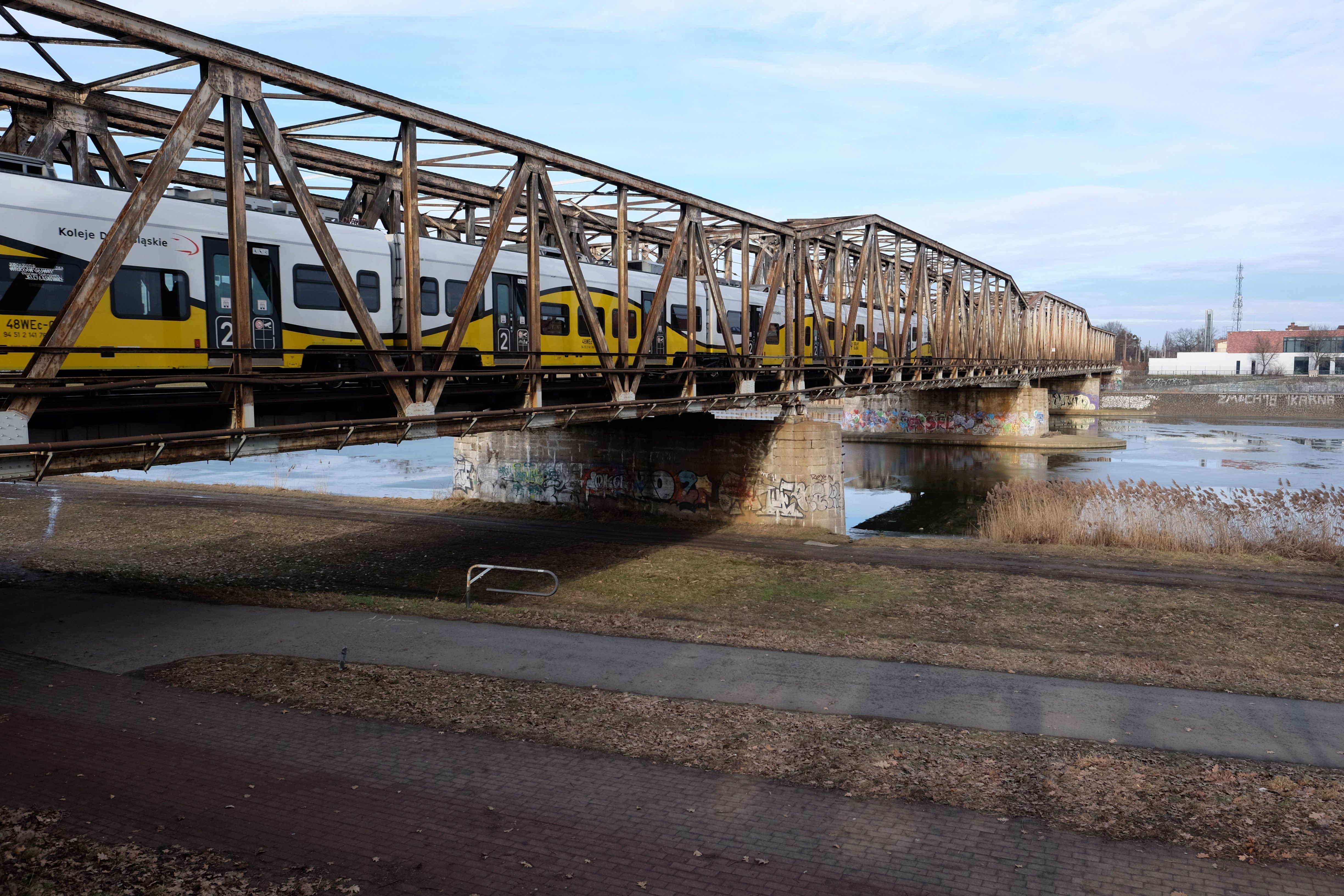 Yellow Train Crossing Historic Iron Bridge · Free Stock Photo