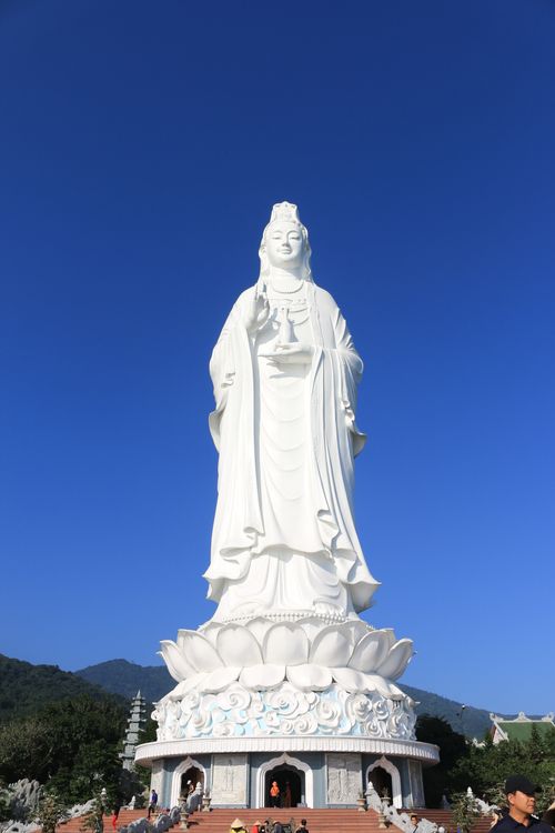 Free A towering Lady Buddha statue overlooking the landscape against a vibrant blue sky in Vietnam. Stock Photo