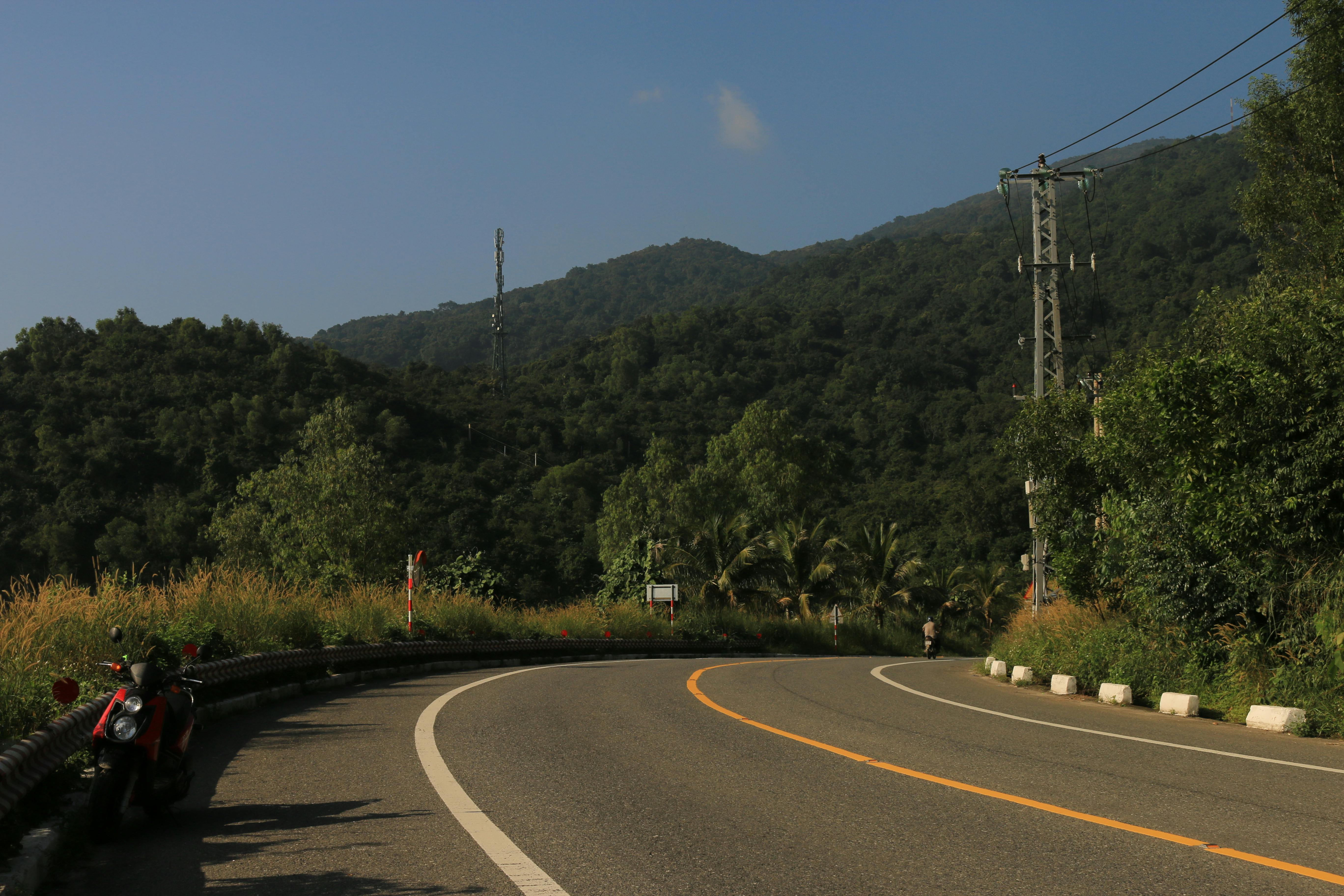 Motorbike on the road with Pico Cão Grande in the background