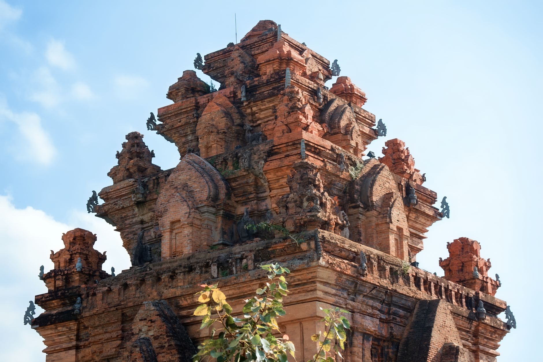 Stunning view of an ancient Cham tower in Vietnam against a clear blue sky, highlighting its intricate architecture.