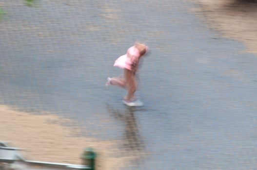 Artistic blur of a child in motion on a wet surface, symbolizing speed and joy.