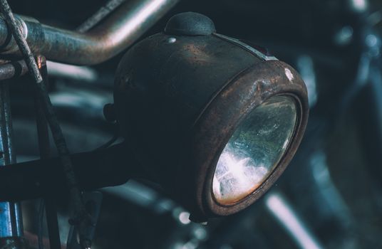Detailed image showcasing a rusted vintage bicycle headlight, highlighting texture and metalwork.