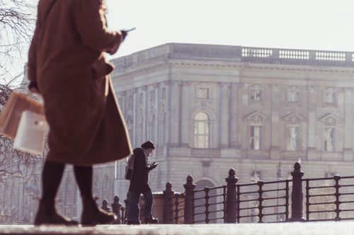 Free City street scene with pedestrians near a historic building, capturing urban life. Stock Photo